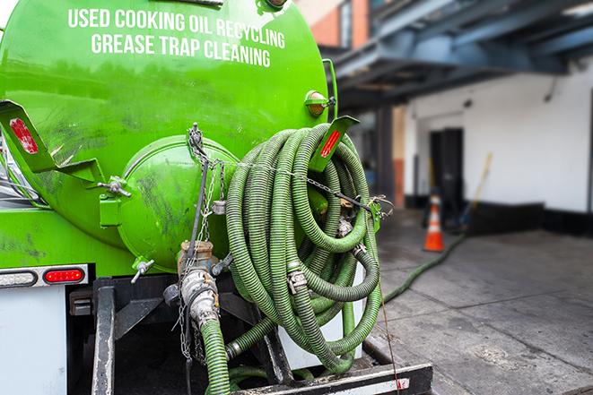 a grease trap being pumped by a sanitation technician in Nesconset, NY